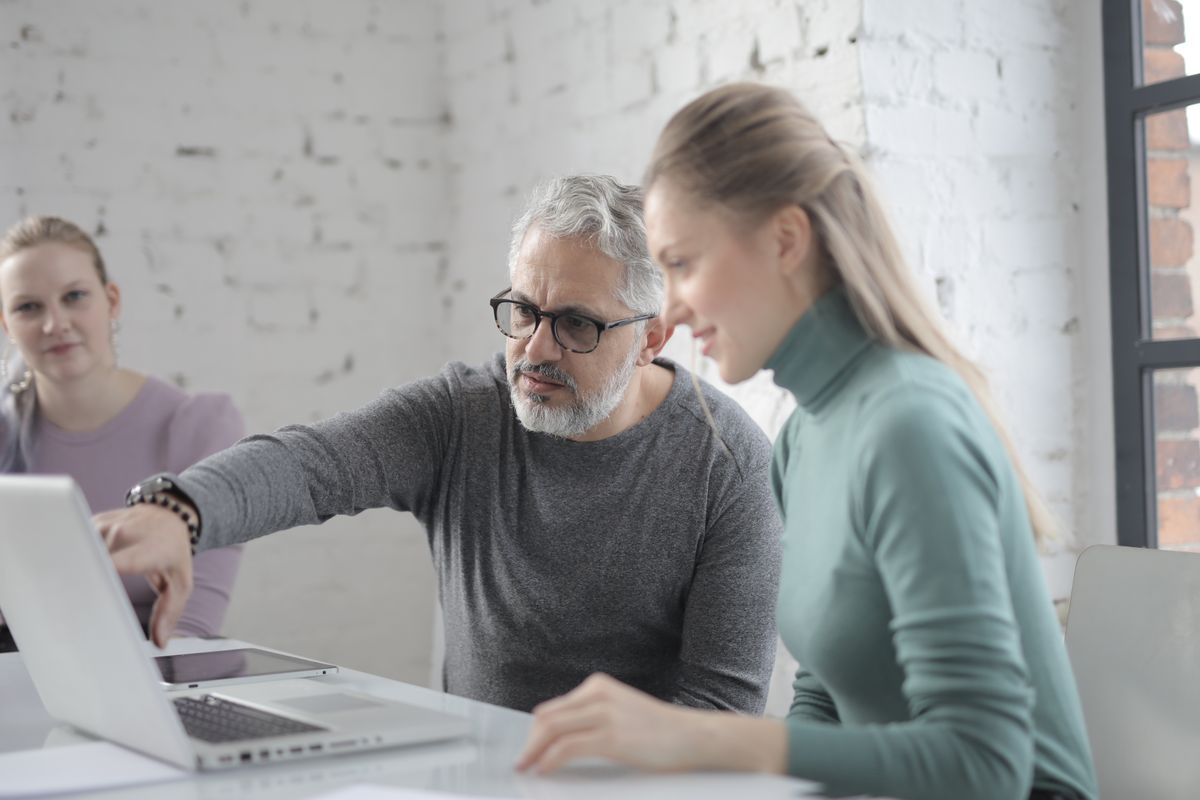 Colleagues going through work on a laptop together